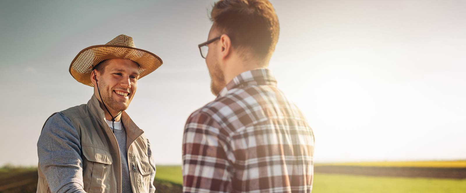 Two men shaking hands in a field